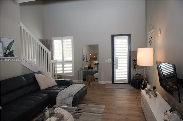 living room featuring a high ceiling and light hardwood / wood-style floors