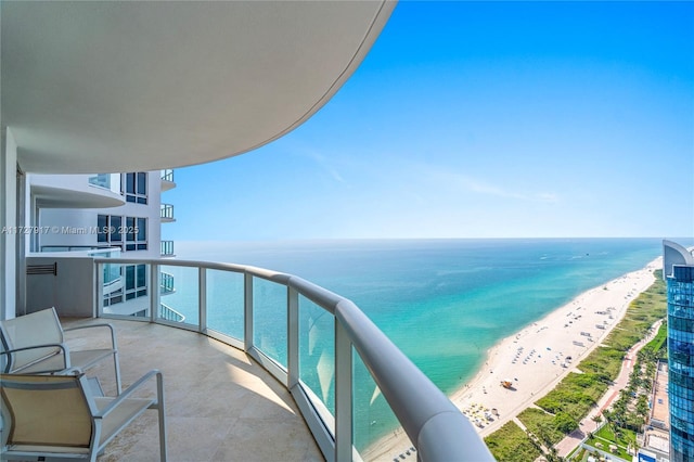 balcony with a water view and a beach view