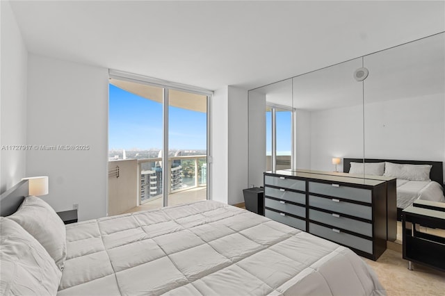 bedroom with light carpet, access to exterior, and expansive windows