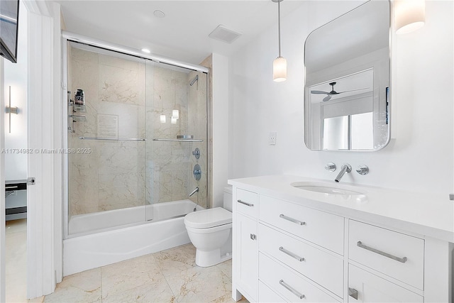 full bathroom with bath / shower combo with glass door, vanity, ceiling fan, and toilet