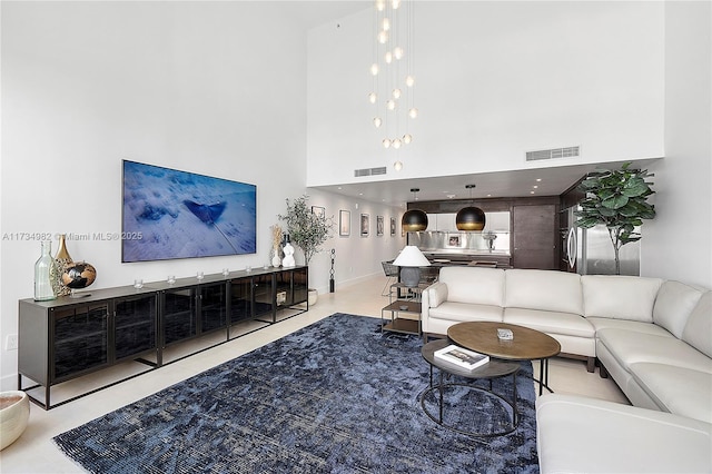 living room with light tile patterned floors and a high ceiling