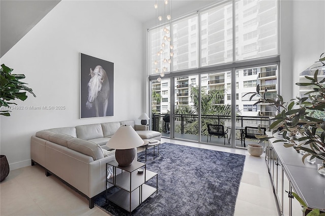 living room with a high ceiling and light tile patterned flooring