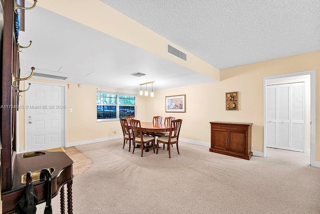 carpeted dining space featuring a textured ceiling