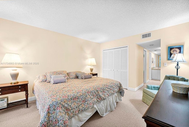 bedroom with light carpet, a textured ceiling, and a closet