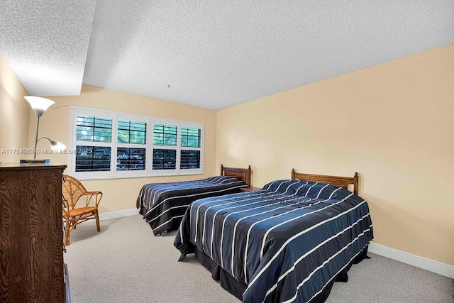 bedroom featuring light carpet and a textured ceiling