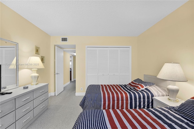 carpeted bedroom featuring a closet and a textured ceiling