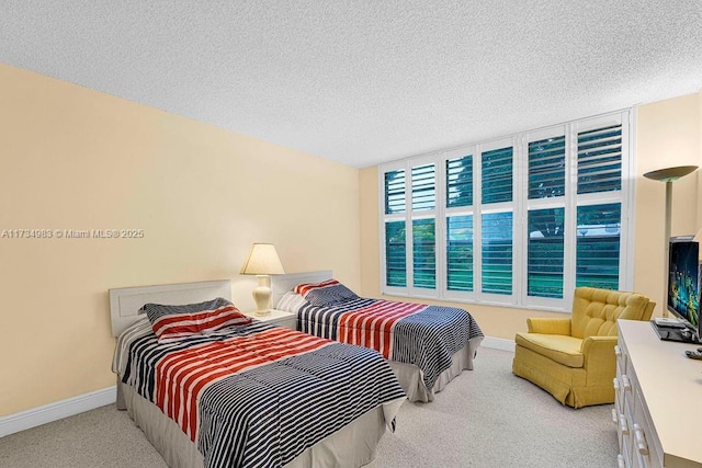 bedroom featuring light colored carpet and a textured ceiling