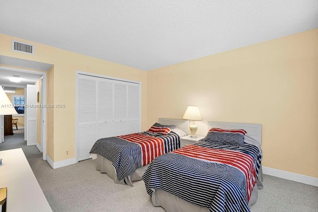 carpeted bedroom featuring a closet and a textured ceiling