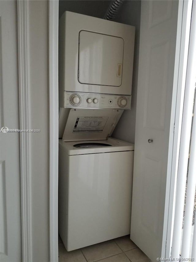 washroom featuring stacked washer and dryer and light tile patterned floors