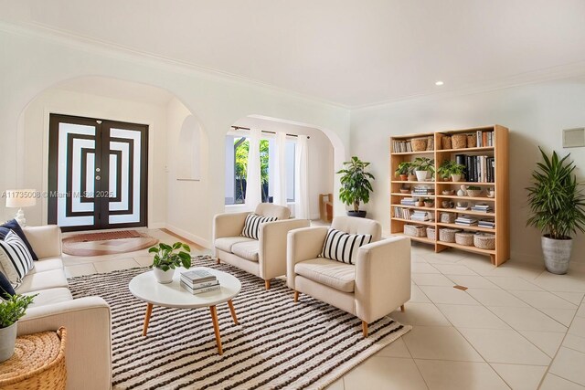 living room with light tile patterned floors and ornamental molding