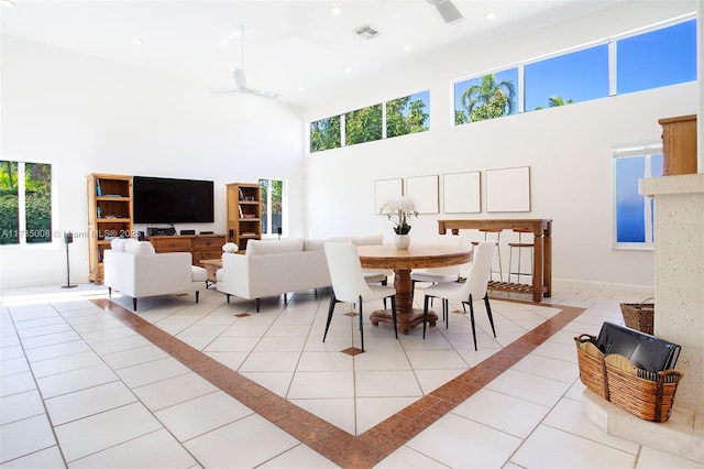 dining space featuring light tile patterned flooring, a towering ceiling, and ceiling fan