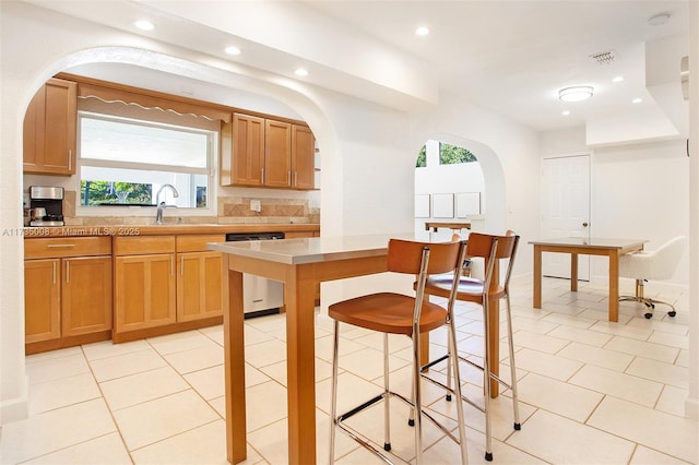 kitchen featuring sink, light tile patterned floors, and dishwasher