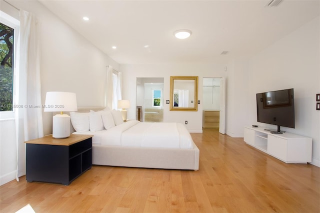 bedroom with multiple windows and light hardwood / wood-style flooring