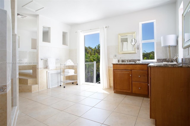 bathroom with vanity, plenty of natural light, tile patterned floors, and tile walls