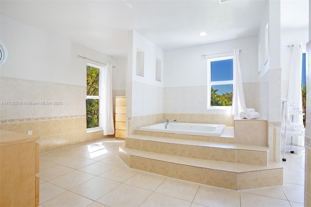 bathroom featuring tile patterned flooring, tile walls, and tiled bath