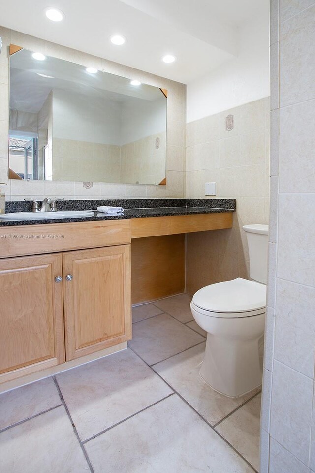 bathroom with vanity, tile walls, tile patterned floors, and toilet