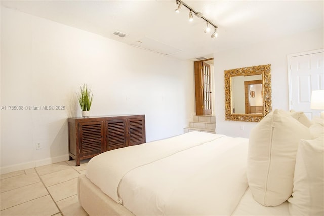 bedroom featuring rail lighting and light tile patterned floors