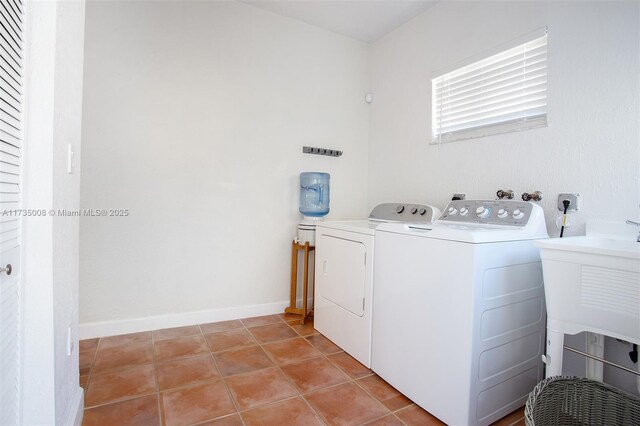 clothes washing area featuring sink, light tile patterned floors, and washing machine and clothes dryer