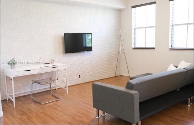 living room with wood-type flooring and brick wall