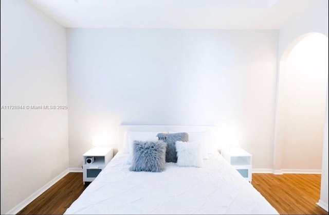 bedroom with dark hardwood / wood-style floors