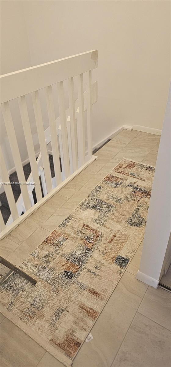 interior space featuring tile patterned flooring and baseboards