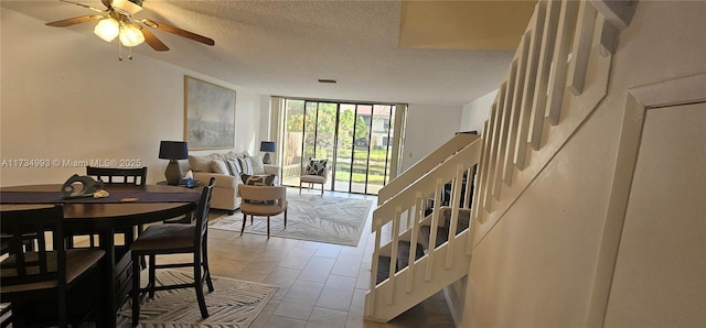 dining area featuring visible vents, a ceiling fan, stairway, a textured ceiling, and floor to ceiling windows