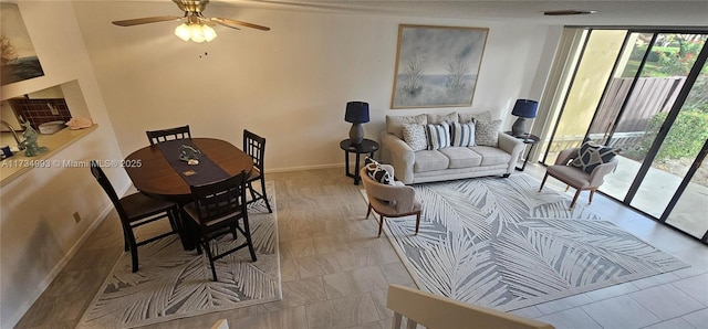 living area featuring visible vents, floor to ceiling windows, baseboards, and a ceiling fan