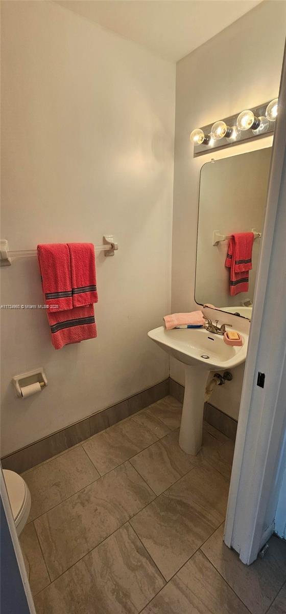 bathroom featuring baseboards and toilet