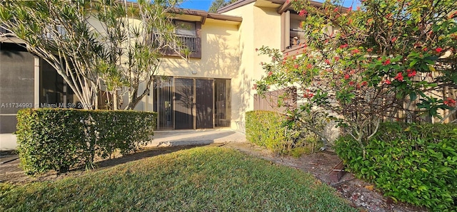 rear view of house featuring stucco siding