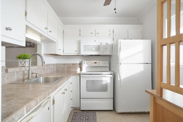 kitchen with light tile patterned flooring, tile countertops, white cabinetry, sink, and white appliances