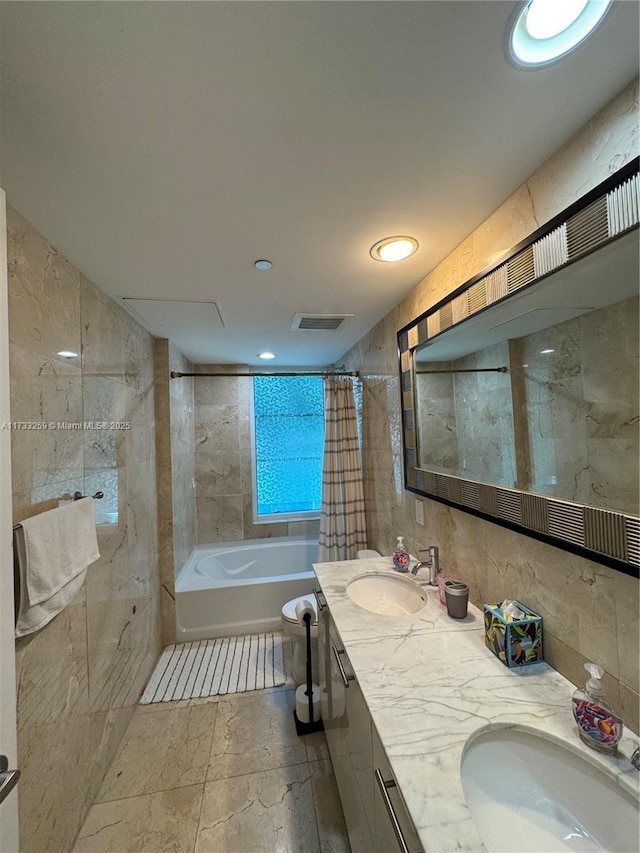 full bathroom with shower / bath combination with curtain, vanity, toilet, and tile walls