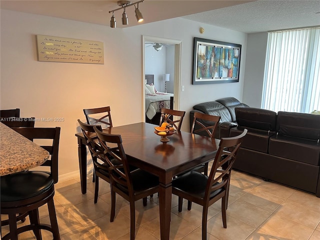 dining room featuring ceiling fan and a textured ceiling