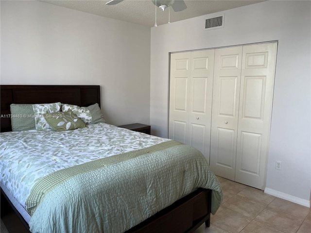 bedroom with a textured ceiling, a closet, and light tile patterned floors