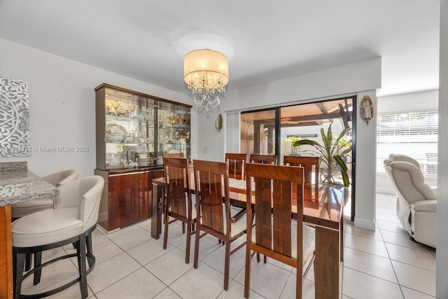 tiled dining room featuring a chandelier