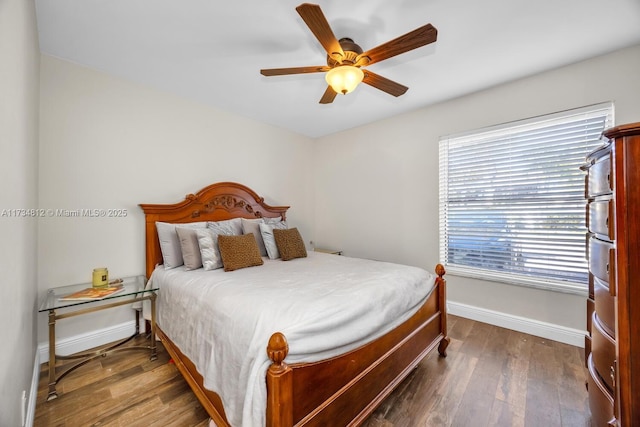 bedroom with dark hardwood / wood-style floors and ceiling fan