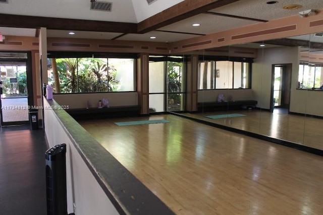 recreation room featuring dark hardwood / wood-style floors and beamed ceiling