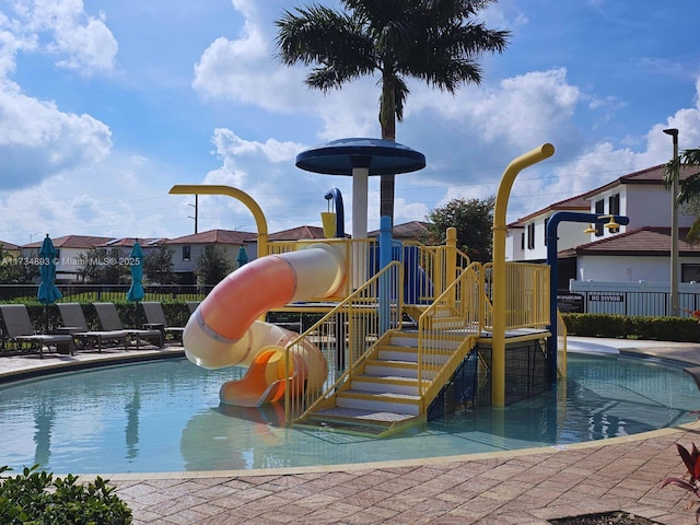 view of pool with a playground and a water slide