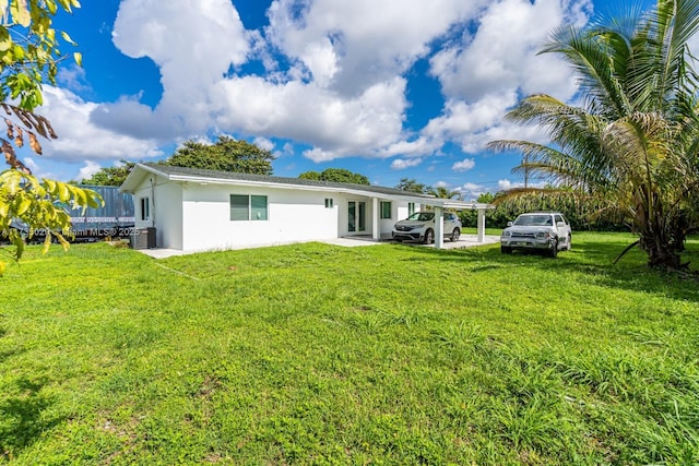 back of property with a lawn and central air condition unit