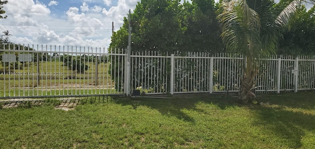 view of gate with a yard