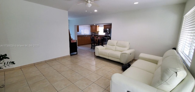 tiled living room featuring ceiling fan and sink