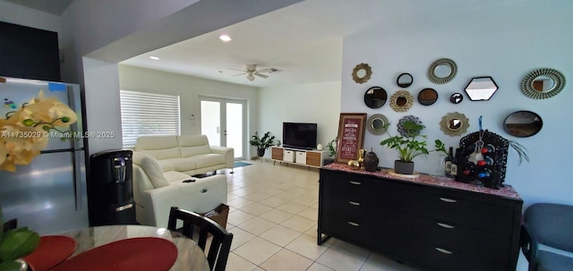 tiled living room with ceiling fan and french doors