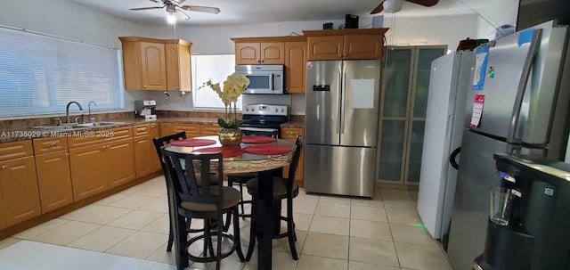 kitchen with appliances with stainless steel finishes, sink, light tile patterned floors, and ceiling fan