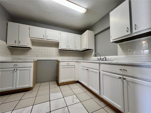 kitchen with white cabinetry, sink, and tasteful backsplash