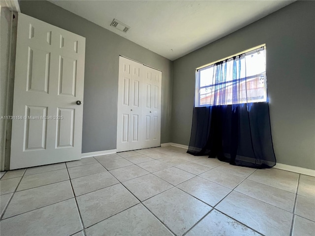 unfurnished bedroom featuring a closet and light tile patterned floors