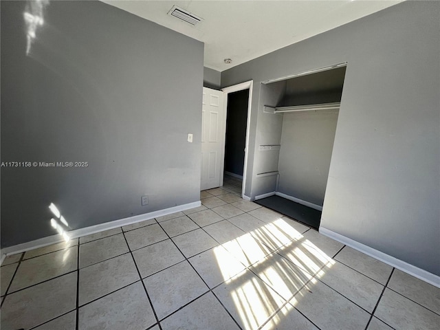 unfurnished bedroom featuring a closet and light tile patterned flooring