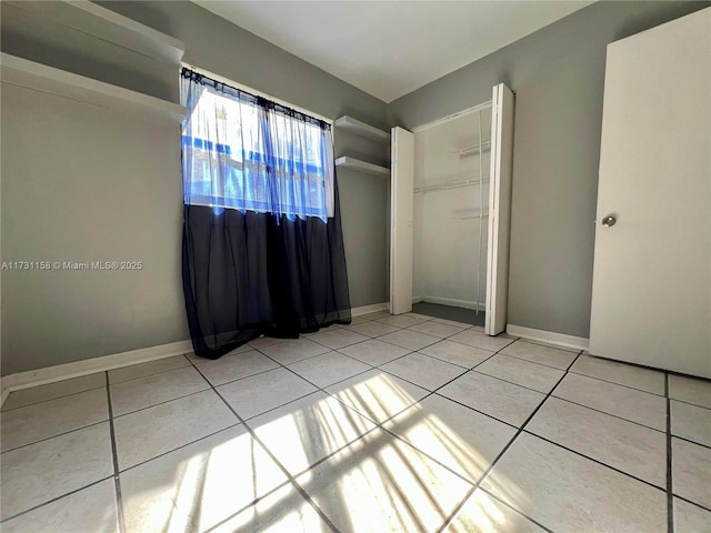 unfurnished bedroom with tile patterned floors and a closet