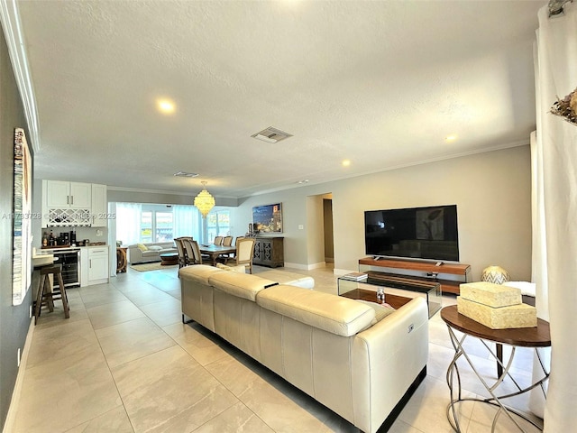 living room with wine cooler, ornamental molding, and a textured ceiling