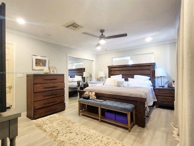 bedroom with ornamental molding, a closet, ceiling fan, and light wood-type flooring