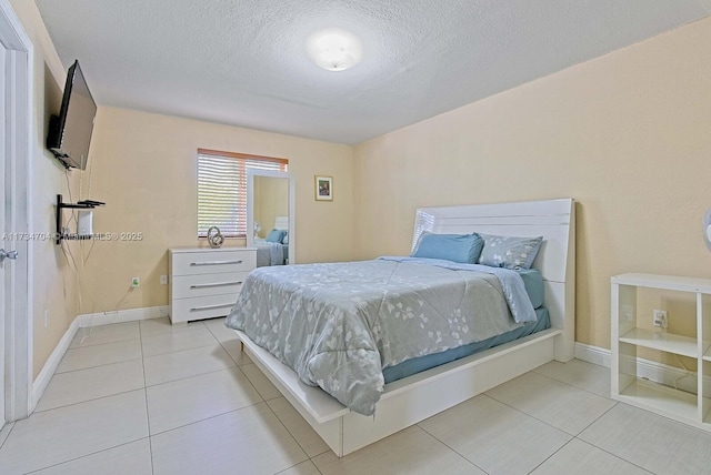 bedroom featuring light tile patterned floors and a textured ceiling