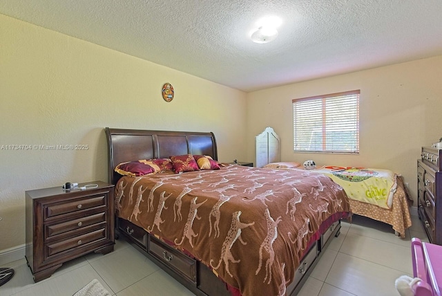 bedroom featuring light tile patterned floors and a textured ceiling